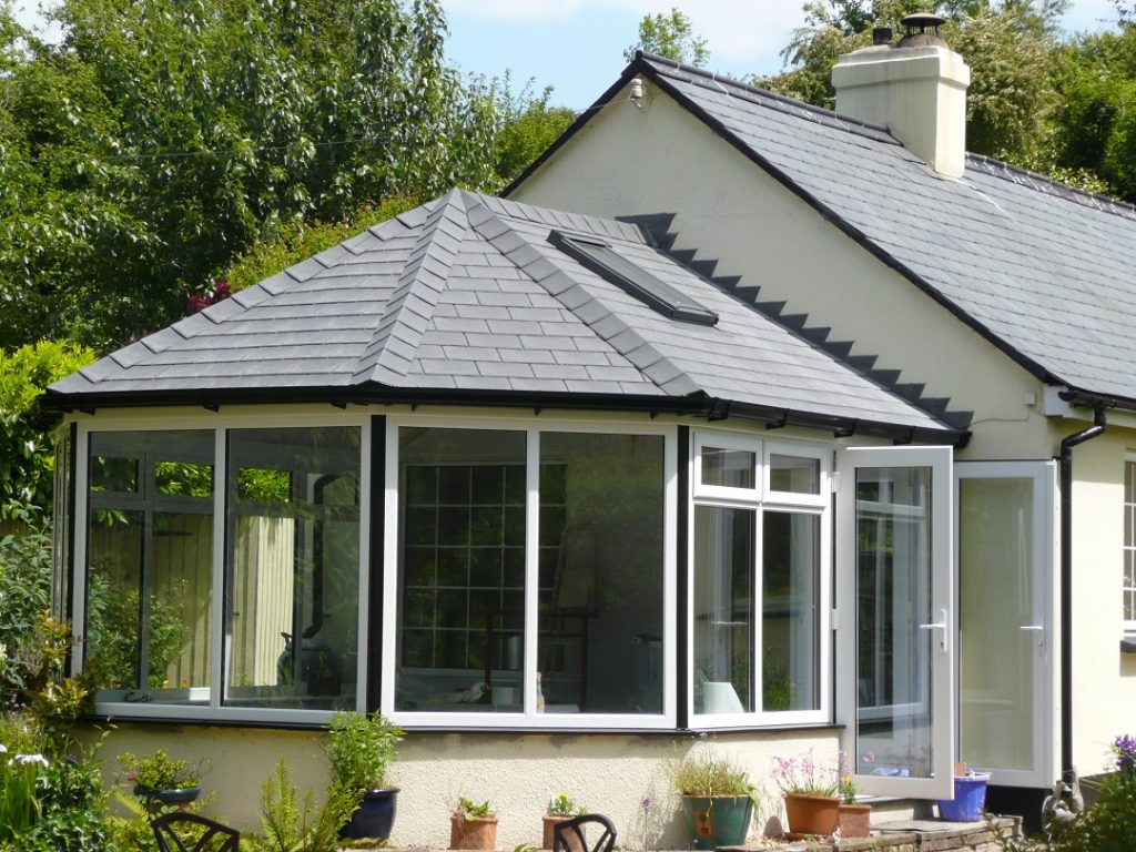 Solid-roofed conservatory by Coastal Windows & Conservatories Conservatory with tiled roof on end of gabled house